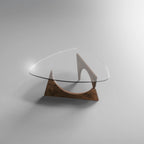 Designer-Couchtisch mit dreieckiger Glasplatte und geometrischem Holzgestell im modernen Stil