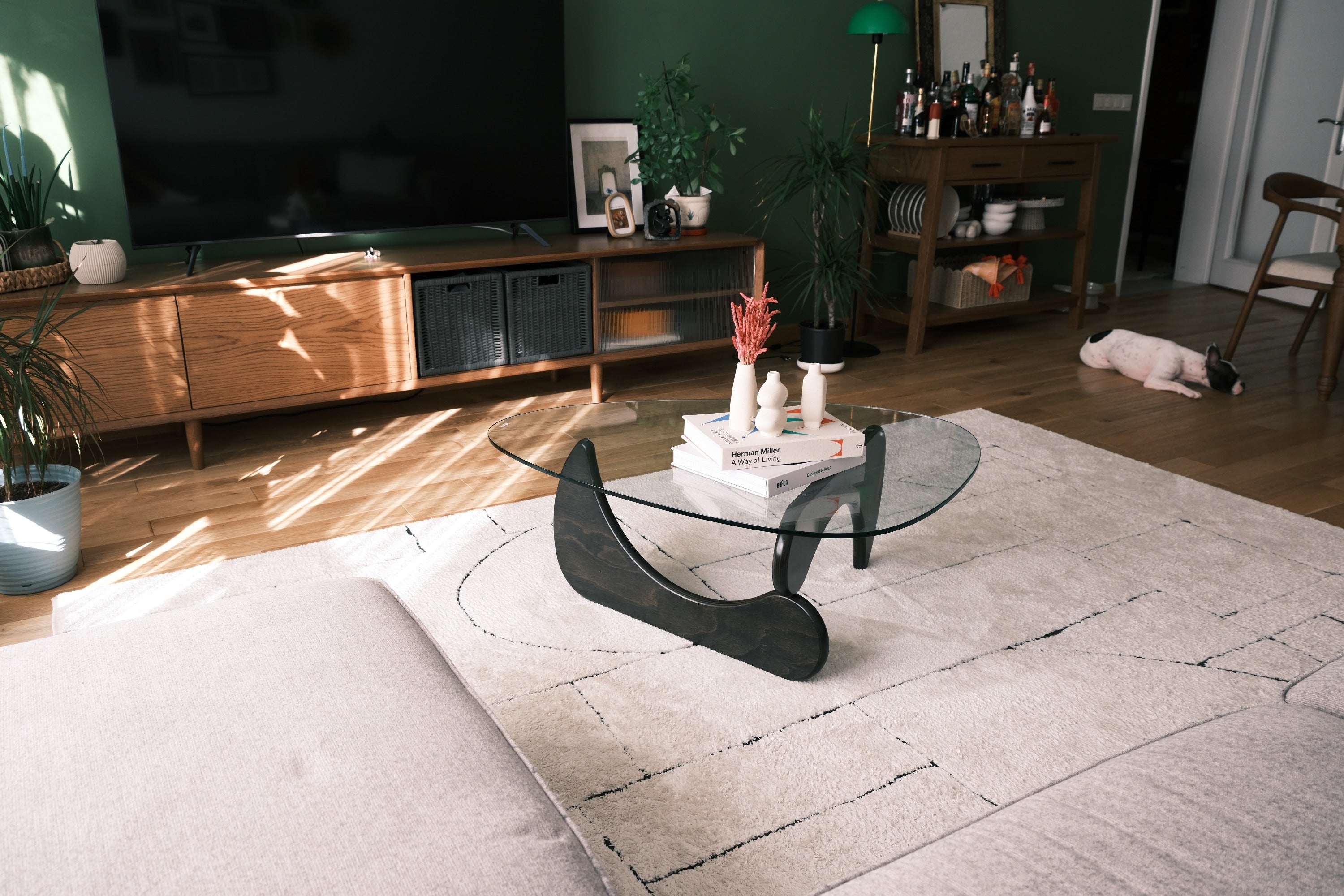 fofofu Couchtisch aus recyceltem Holz mit Glasplatte und organisch geformtem Gestell – handgefertigtes Designerstück in einem modernen Wohnzimmer mit grüner Wand, natürlichem Lichteinfall und wohnlicher Atmosphäre.